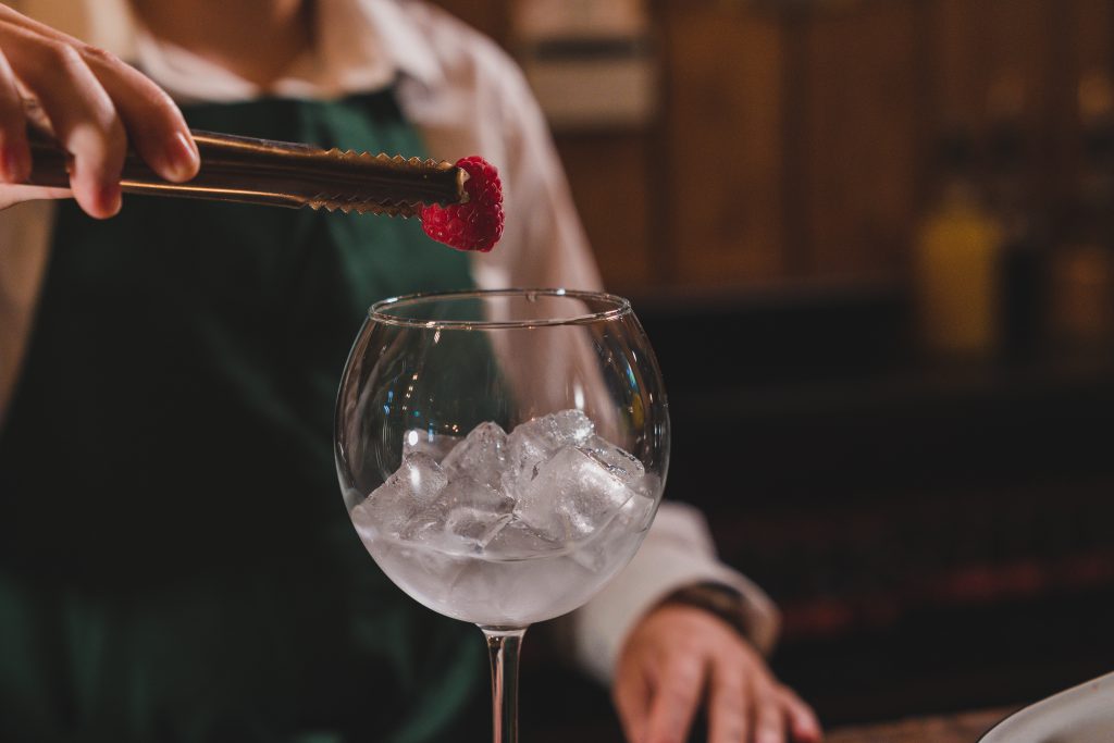 bartender adding a rasberry to garnish a drink at The Crowes Nest