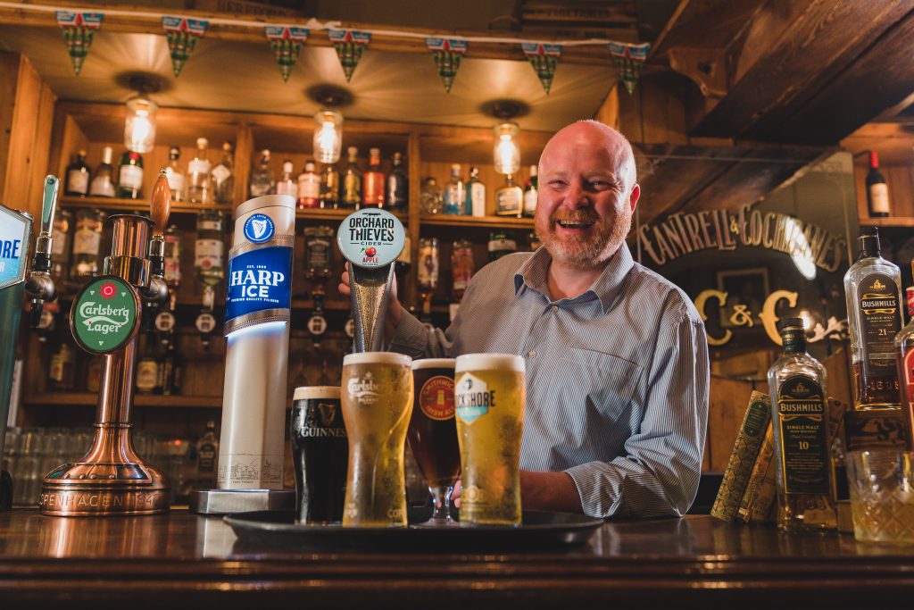 bartender preparing tray of pints of Guinness, Carlsberg, Rockshore and Smithwicks in the Crowes Nest bar