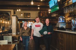 waitress at Crowes Nest walking couple to their table gluten free dining Enniskillen