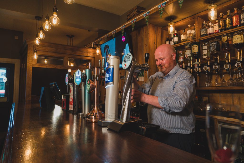 pulling pint at The Crowes